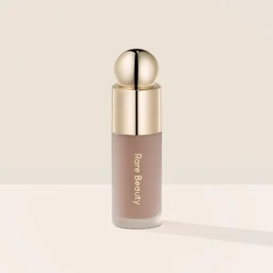 Rare Beauty Soft Pinch Liquid Contour in Gentle – a sleek frosted bottle with a doe-foot applicator containing a light cool brown liquid.